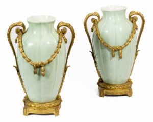Paire de grands vases à côtes en porcelaine dite couleur céladon et monture en bronze ciselé et doré. Le corps, flanqué de poignées enroulées, est orné d'acanthes, de guirlandes et de frises de lauriers grainés.  Il repose sur une base à quatre pieds embellie de rosaces.  Paris. Fin du XIXème siècle. H_ 41 cm  Résultat avec frais : 3 804 €